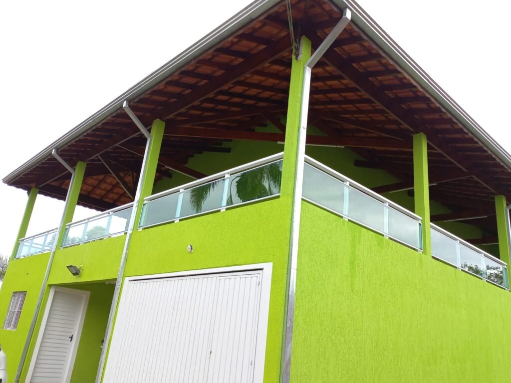 Fachada residencial com guarda-corpo de vidro fumê e estrutura branca em Poá SP